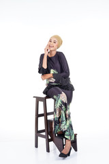 Fototapeta premium Beautiful female model wearing modern kurung, a modern urban lifestyle apparel for Muslim women isolated on white background. Beauty and hijab fashion concept.