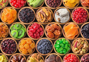 assorted dried fruits and berries in wooden bowls, top view. organic food background