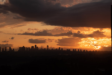 Urban area silhouette on sunset sky background.