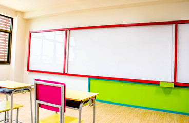 Desks, chairs and white board in the kindergarten classroom.