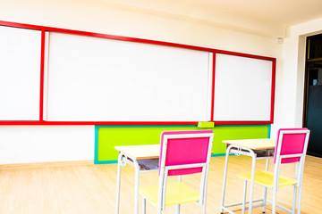 Desks, chairs and white board in the kindergarten classroom.