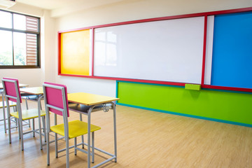 Desks, chairs and white board in the kindergarten classroom.