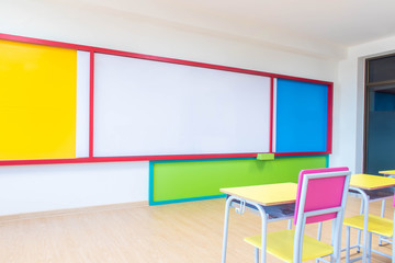 Desks, chairs and white board in the kindergarten classroom.