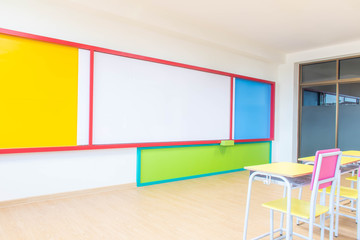 Desks, chairs and white board in the kindergarten classroom.