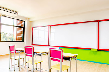 Desks, chairs and white board in the kindergarten classroom.