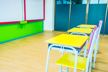 Desks, chairs and white board in the kindergarten classroom.