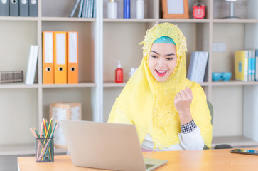 Happy successful lucky young Arab muslim woman smiling joyfully, cheering, feeling excited, gesturing with hand