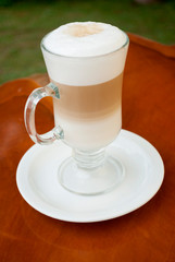 Glass cup served with Capuccino coffee, aromatic coffee from Guatemala served outdoors, relaxing and natural space.