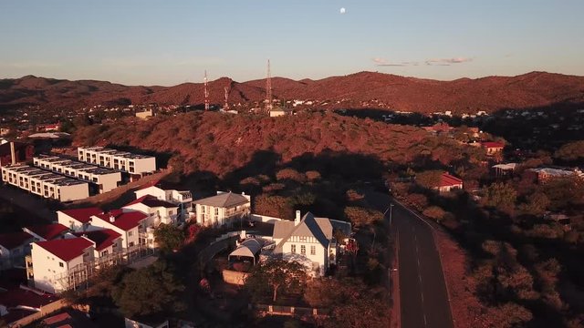 4K aerial Windhoek capital residential central hilly district bright sunset drone video with upmarket houses and old white walls German mansion on top of hill in Khomas Region, central Namibia