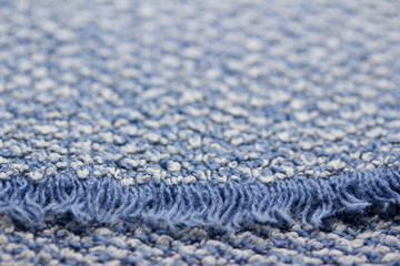 Defocused macro abstract texture background of a vintage worn blue color cloth towel with a fringe