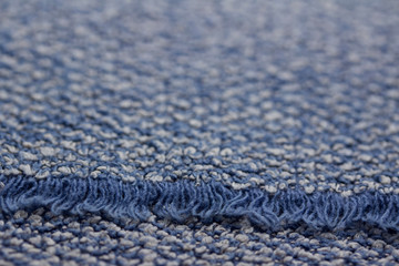 Defocused macro abstract texture background of a vintage worn blue color cloth towel with a fringe
