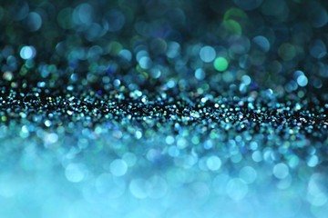 Turquoise glitter bokeh background.Blue glitter with green bokeh on a black background. Turquoise Vibrant background with twinkle lights.blue shiny glitter layout. glitter brilliant mockup
