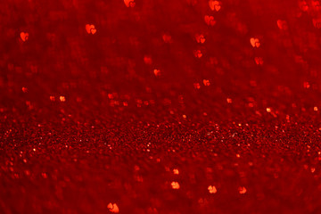 Abstract macro shot of red glittering paper with heart bokeh. Valentine's Day and love, mother day or Christmas concept. Decoration for banner, postcard, backgrounds 