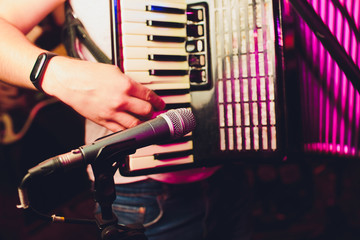 The musician plays the accordion close-up microphone.