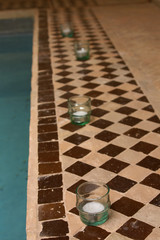 small pool with mosaic tile and candles.