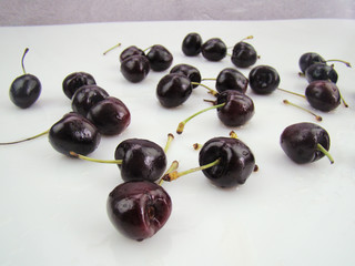 Freshly dripped cherries on a white background