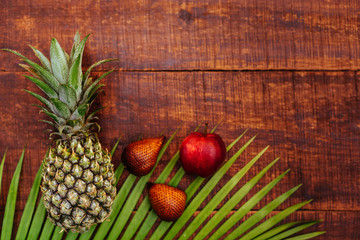 Tropical fruit on dark wooden background, top view
