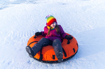 Fototapeta na wymiar happy child riding on the tubing . inflatable sledges
