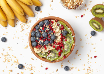 Healthy summer breakfast with granola, blueberries, bananas, kiwi and pomegranate. Healthy food nutrition, snack or breakfast. Top view. 