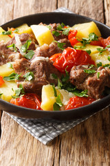 Caucasian cuisine khashlama slowly stew with vegetables close-up in a bowl on the table. vertical