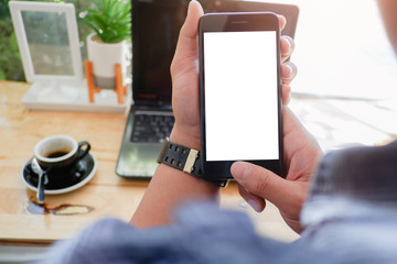 Mockup picture of business woman’s hands or man's hands holding smart phone with white blank screen in modern place.
