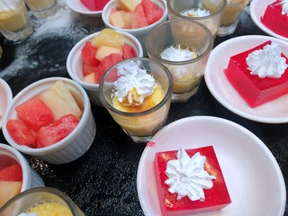 Top view of sweet red strawberry jelly topped with whip cream, chocolate mousse, strawberry yoghurts and mixed fruit in cup as a background in restaurant, summer dessert