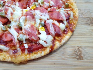 Top view of pizza with sausage mixed vegetable topped with mayonnaise on wooden cutting board in restaurant, Ready to eat or serve, Space for your text