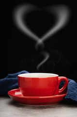 Red cup of hot coffee with smoke forms a heart symbol on black background. valentine's day concept.