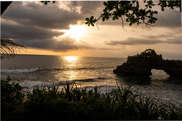 Rock formation and beach of Tanah lot. A famous tourist destination and surfing beach at Bali Island, Indonesia