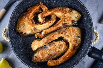 Slices of baked carp fish in frying pan, a traditional Polish Christmas dish
