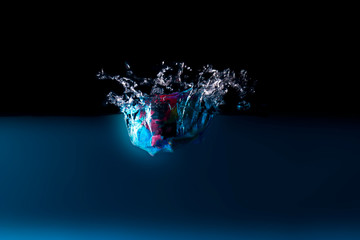 The object falls into the blue water until a sponge splits beautifully on a black background.