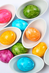 bunte Ostereier in weissen Schalen