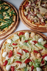 Three different pizza on wooden boards