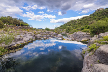 Fototapeta na wymiar Clouds reflects in waters of Alcantara river on Sicily Island in Italy