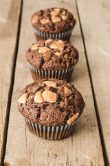 Three chocolate muffins lined up.