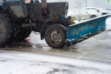 Blurred motion shot of a tractor plowing snow