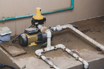 Water pump plumbing and pvc pipes exterior set-up in a home. DIY, repair, plumbing concepts.