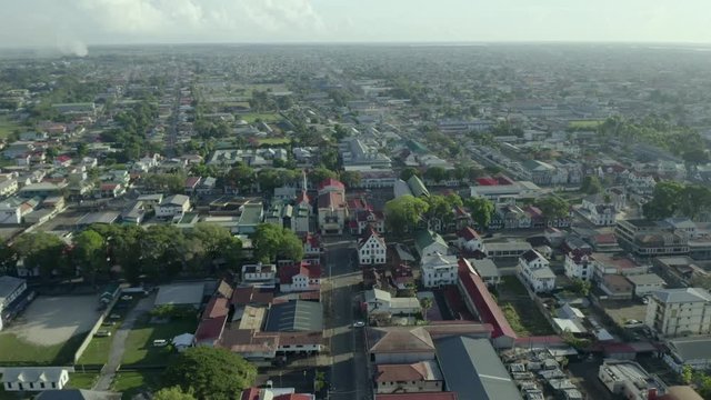 Birds eye view of the cultural and historic city of Paramaribo, capital of Suriname. Aerial, Backward moving. 