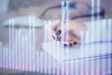 Multi exposure of hands making notes with forex chart huds. Stock market concept.