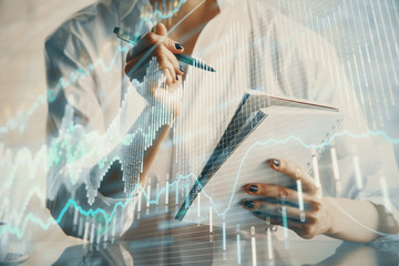 Fototapeta premium Financial chart drawn over hands taking notes background. Concept of research. Multi exposure