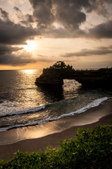 Rock formation and beach of Tanah lot. A famous tourist destination and surfing beach at Bali Island, Indonesia