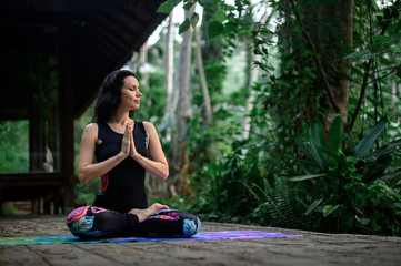 Yoga practice and meditation in nature. Woman practicing near river