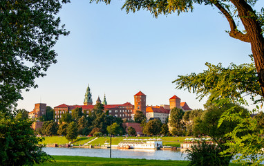 Krakow, Poland. Historic royal Wawel castle, cathedral and Vistula River naturally framed with tress in fall in sunset light