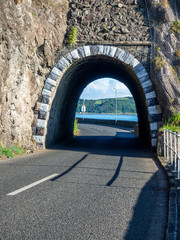 Black Arc tunnel  with rockfall, landslide net protection and Causeway Coastal Route. Scenic road along eastern coast of County Antrim, Northern Ireland, UK