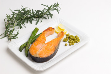 Grilled salmon green peas, lemon sprig of rosemary. Red fish source omega -3