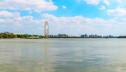 Fototapeta premium Ferris wheel architectural landscape and lake in Suzhou during daytime