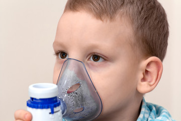 Child with asthma problems making inhalation with mask on face. Sick kid a respiratory infection or...