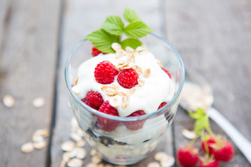Healthy yogurt dessert with muesli, raspberries and black currants.