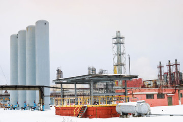 Large installation with equipment for heat exchangers with tanks and columns at an industrial refinery petrochemical chemical plant in the snow in winter