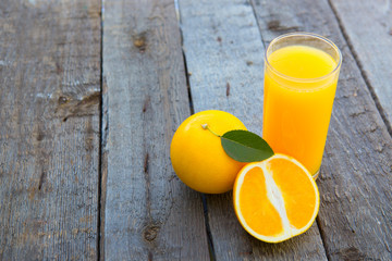 Glass of freshly pressed orange juice on dark wooden table